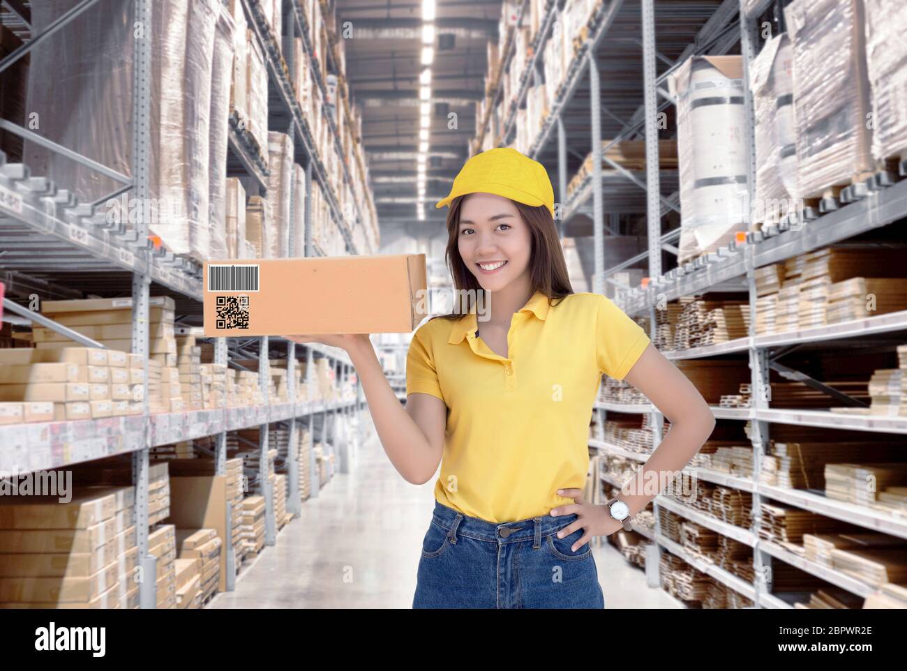 Asian woman show paper box inventory from warehouse with smile. good and easy shipping service with barcode and qr code to control stock. Stock Photo