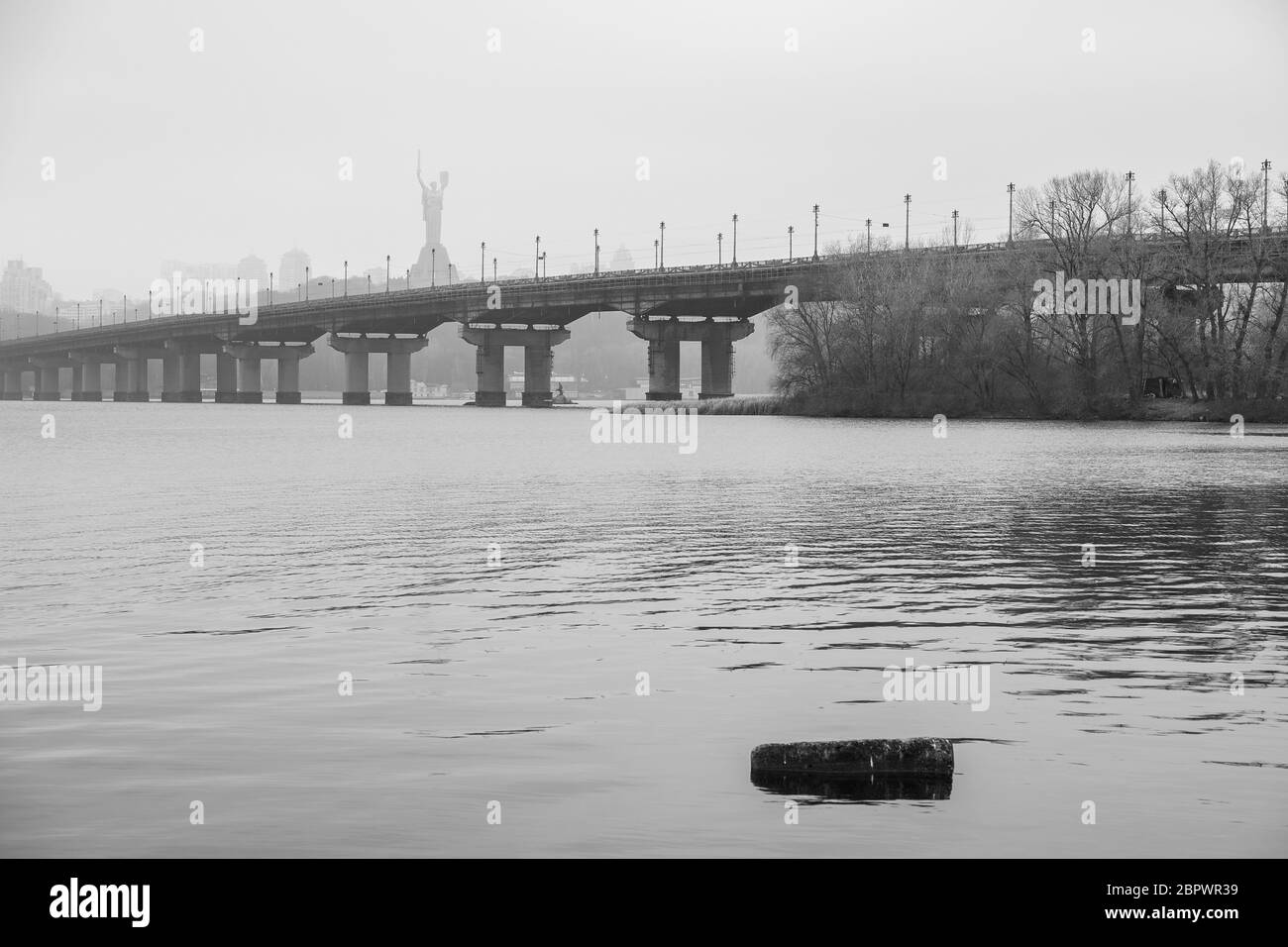 Wide river Dnieper with a bridge after sunrise with beautiful clouds B and W Stock Photo