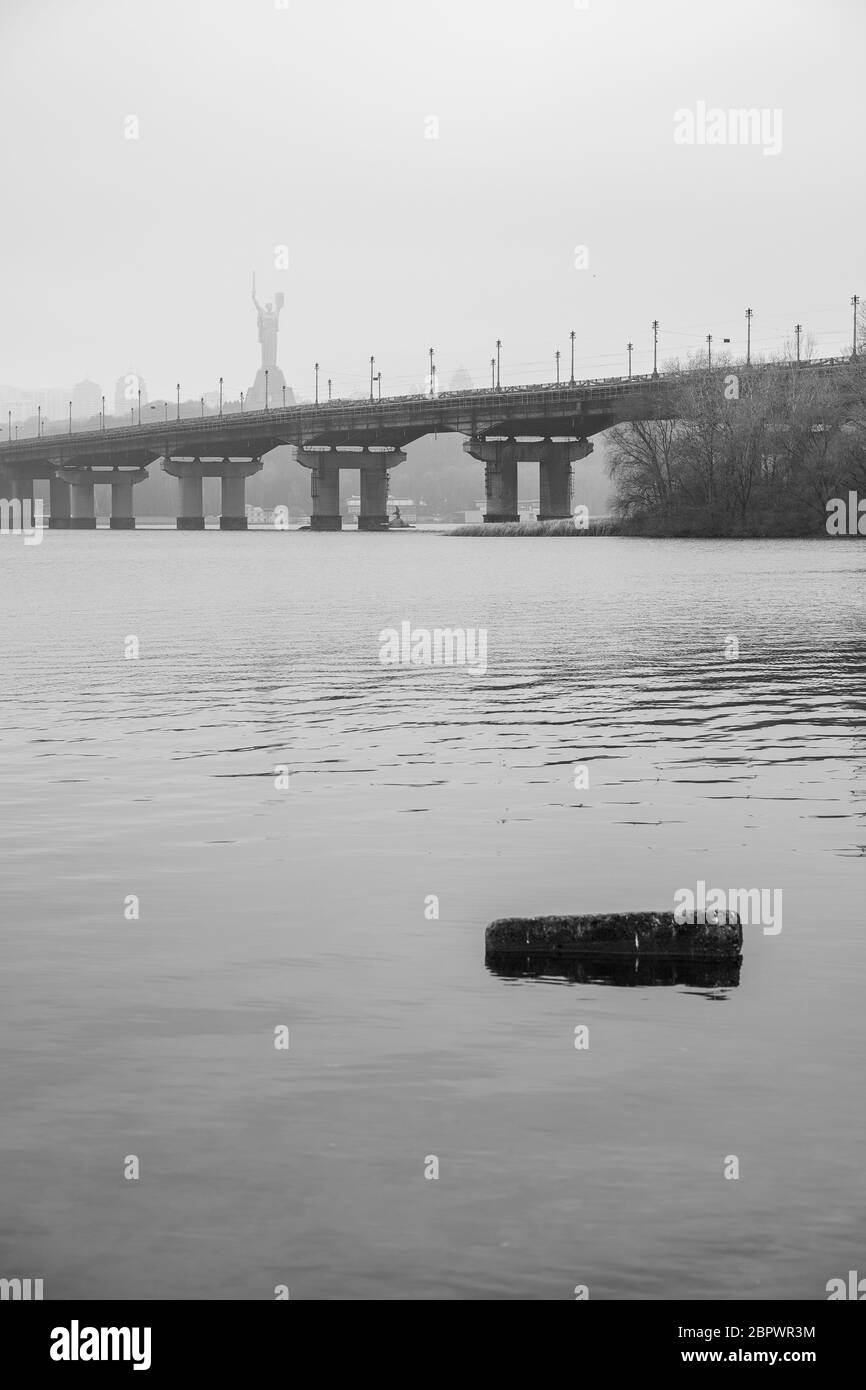Wide river Dnieper with a bridge after sunrise with beautiful clouds B and W Stock Photo