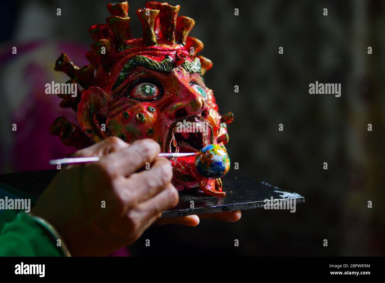 Amit Modak, an Indian Artist whose business is handicraft,  is seen here finishing some masks/ faces in model for the coronavirus during a government-imposed nationwide lockdown to prevent the spread of the virus. Agartala, capital of the Northeastern state of Tripura, India. Stock Photo