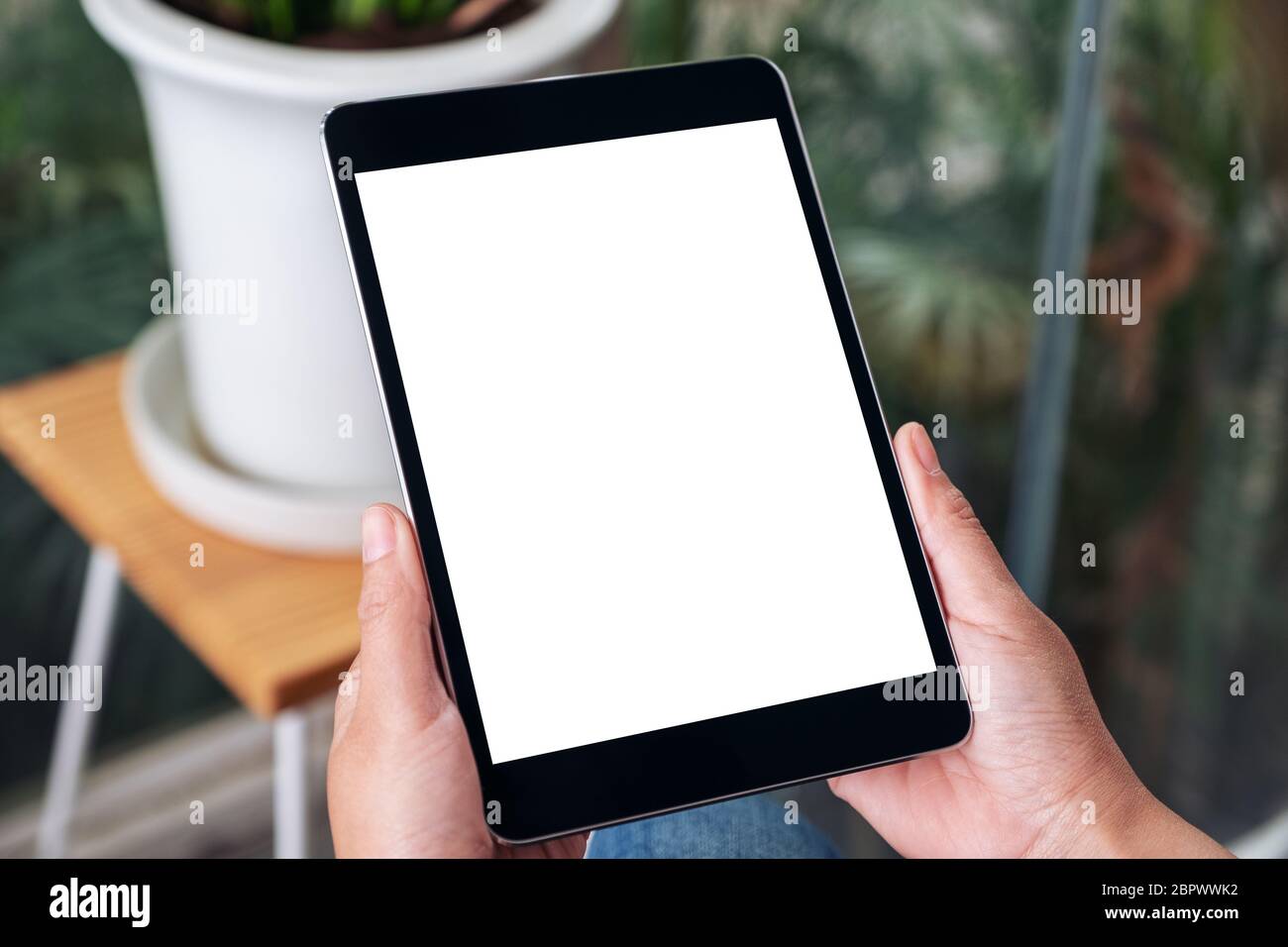 Mockup image of hands holding black tablet pc with blank white screen ...