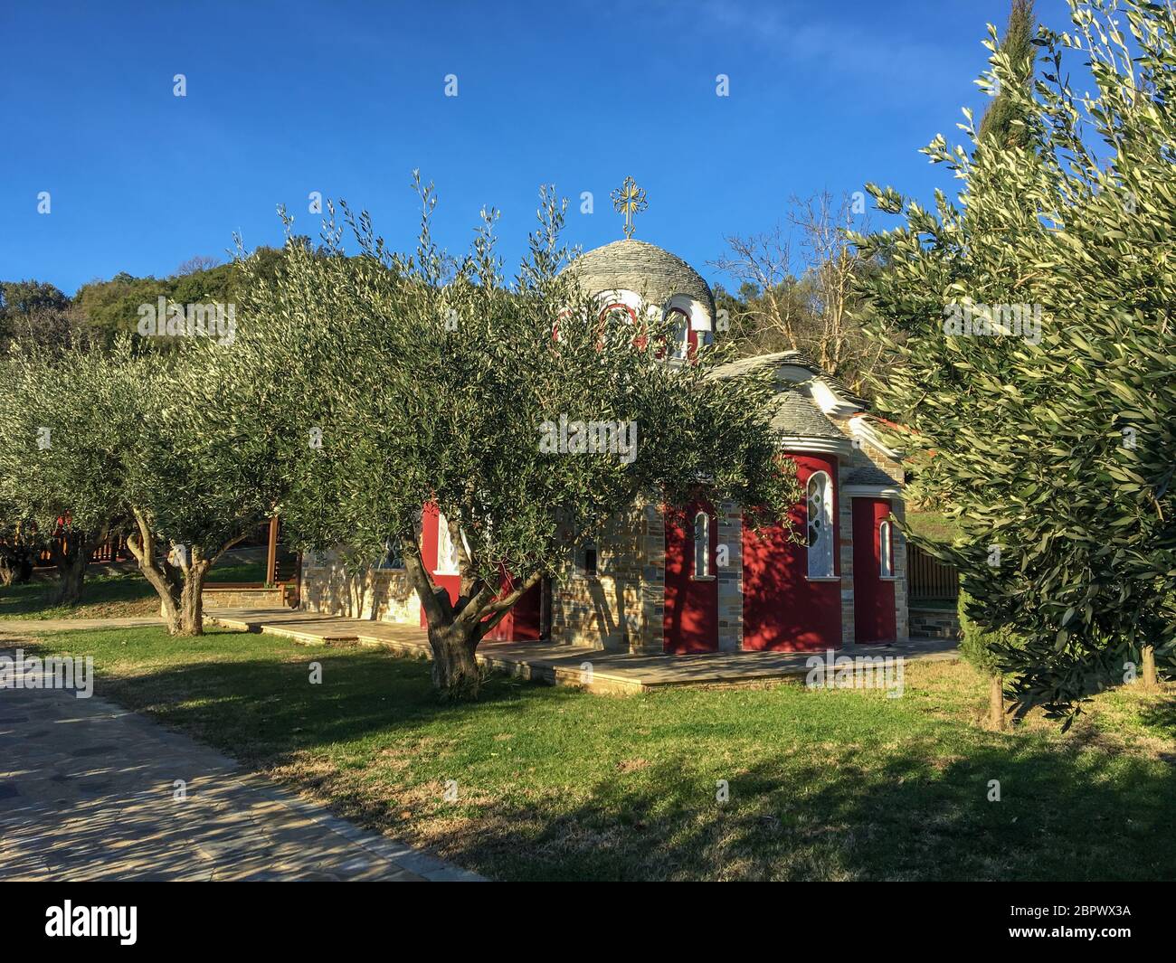 A small church on Mount Athos with red walls, tiled with a baptistery and a bell Stock Photo