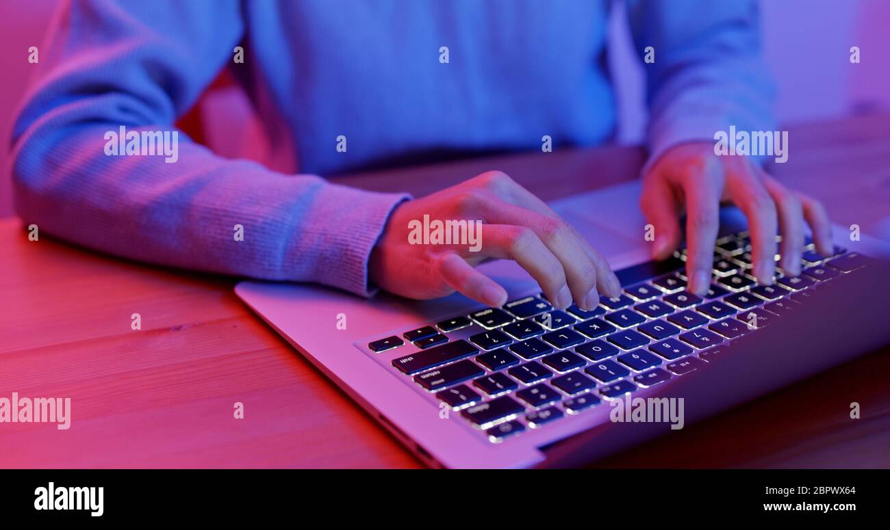 Finger type on keyboard at night Stock Photo