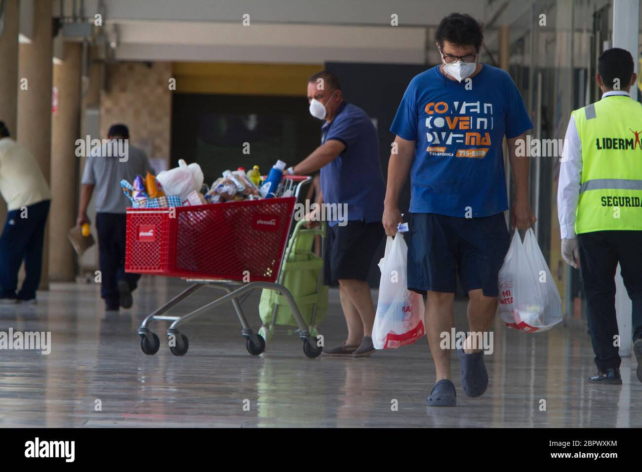 A man wearing a mask carries bags of groceries from the supermarket during the national state of mandatory quarantine as a response to the COVID-19 pandemic in Lima, Peru. Since the installment of the measure back in March the government have struggled to stop the spread of the virus especially in public areas such as markets. 33,931 people have been infected and 943 have died as of April 29, 2020. Stock Photo