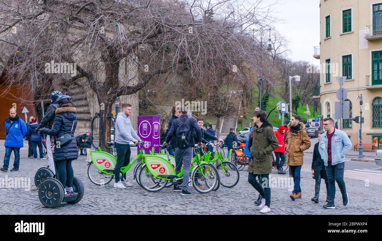 BUDAPEST, HUNGARY - 03 16 2019 : Young tourists use the mol's Bubi bikes at the Buda Castle Tunnel. Stock Photo