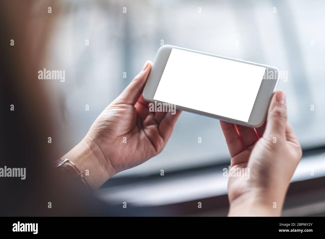 Mockup image of a woman holding white mobile phone with blank desktop ...