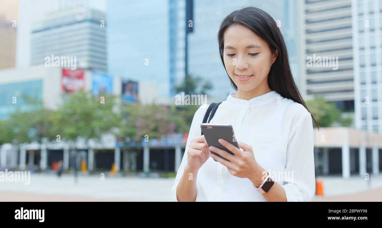 Woman look at mobile phone in city of Hong Kong Stock Photo - Alamy