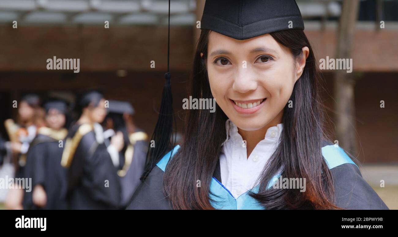 Woman smile to camera in university campus for graduation ceremony
