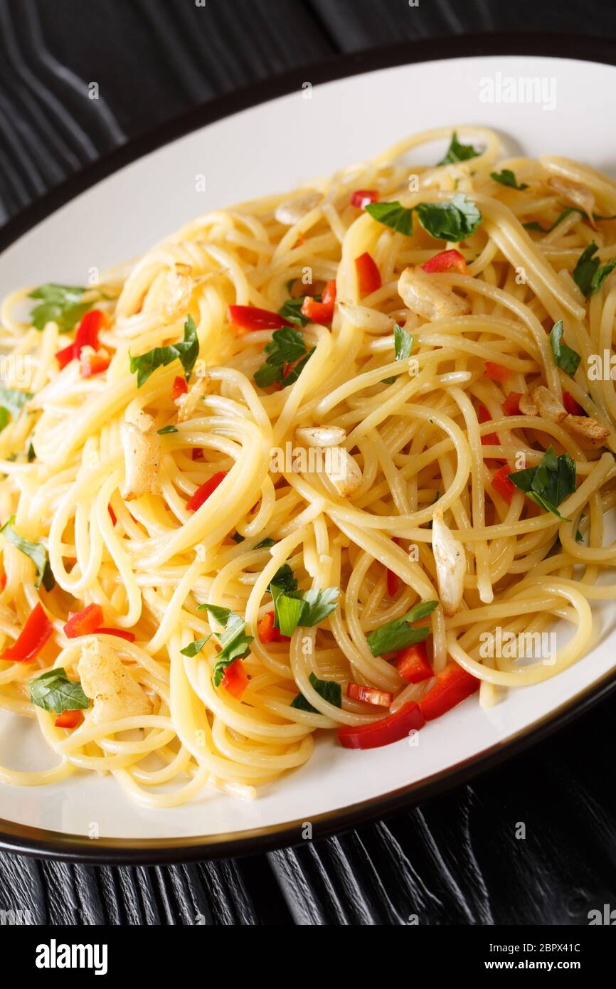 Spaghetti Aglio e Olio is a simple Italian dish of garlic, olive oil, parsley closeup in a