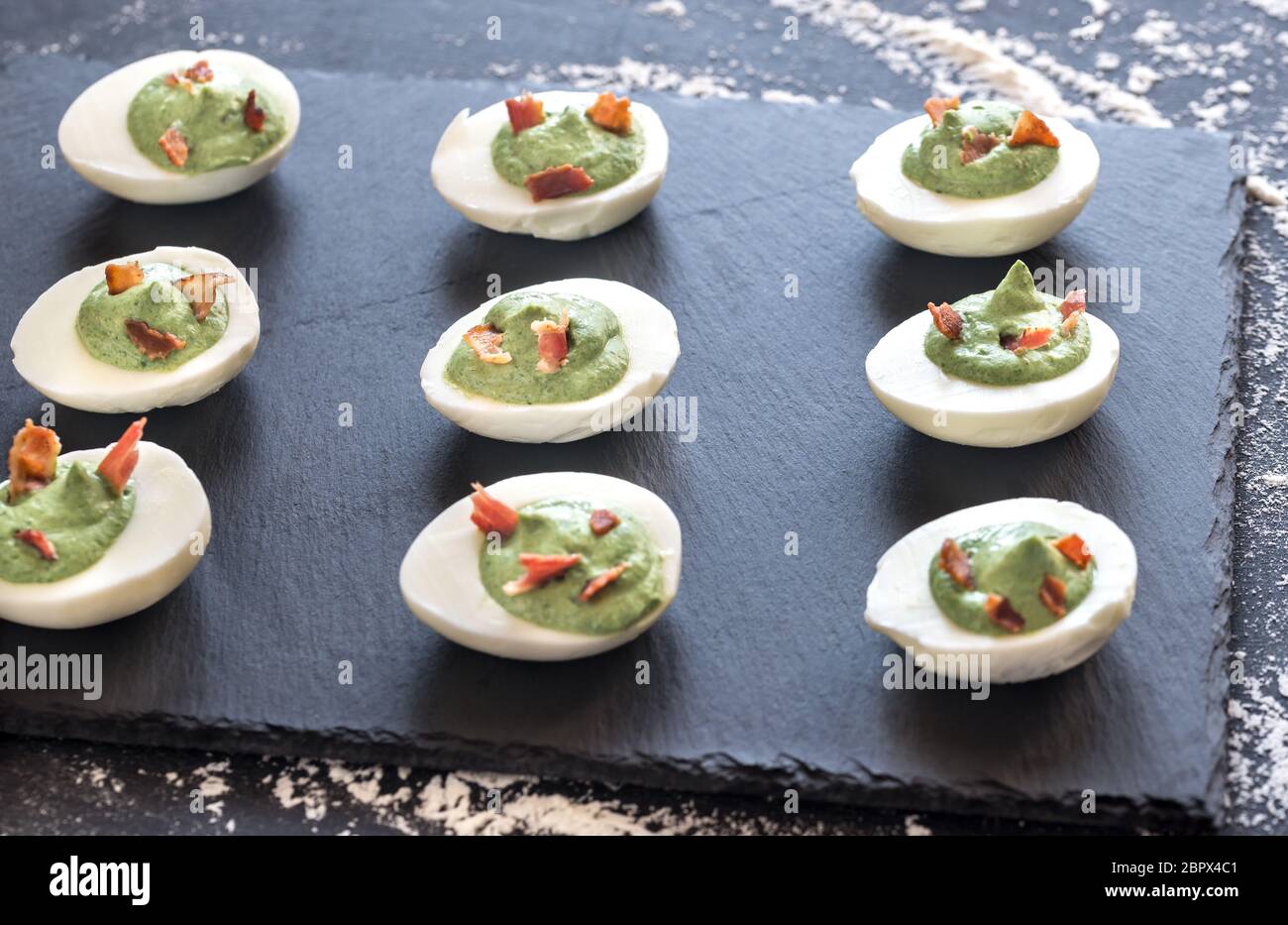Spinach and bacon deviled eggs Stock Photo
