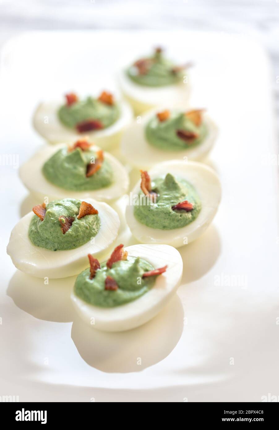 Spinach and bacon deviled eggs Stock Photo