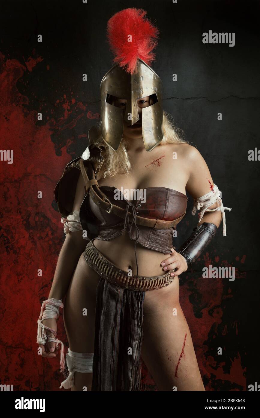 Ancient woman warrior or Gladiator posing in a dark background Stock Photo