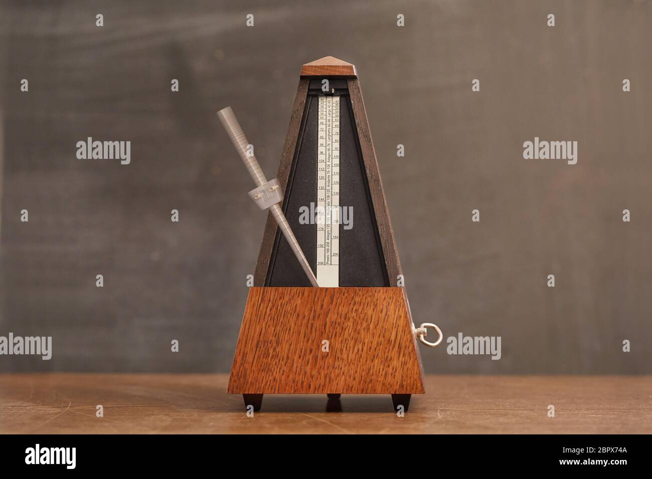 Classic metronome on a table, motion blurred hand Stock Photo Alamy
