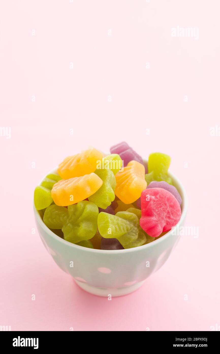 Fruit jelly candies in bowl on colorful background. Stock Photo