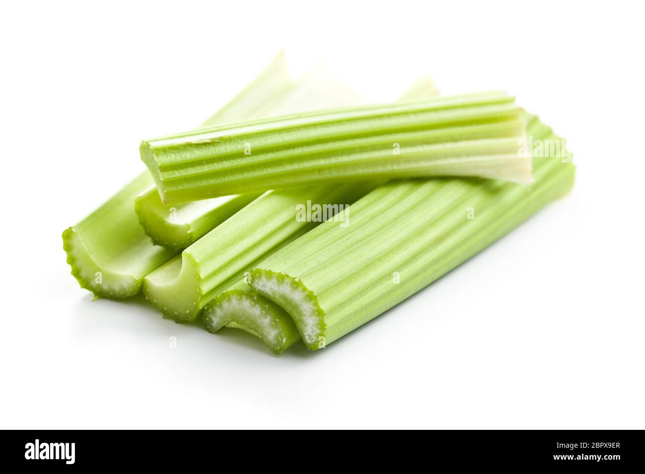 Celery sticks. Cutting celery stalks isolated on white background. Stock Photo
