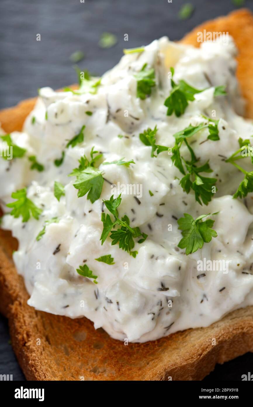 Herring salad on toast with herbs - close up view Stock Photo