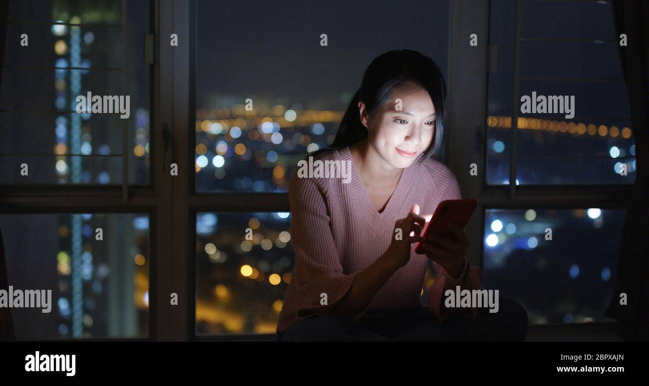 Woman look at mobile phone at night Stock Photo - Alamy
