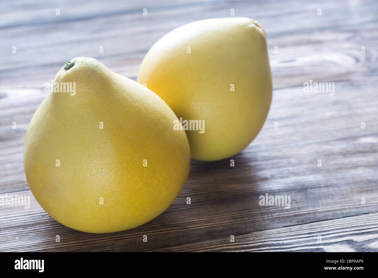 Two pomelos on the wooden background Stock Photo