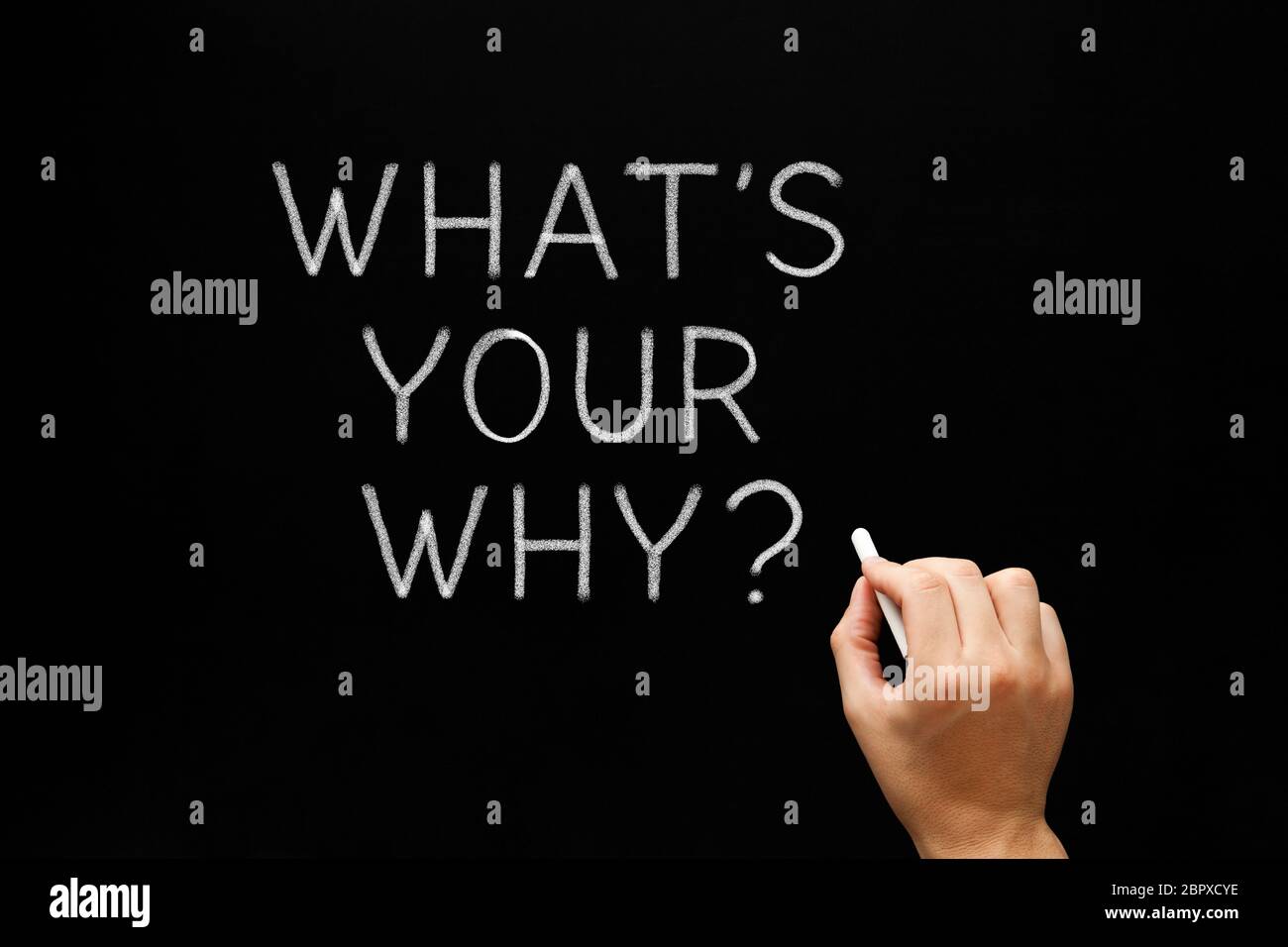 Hand writing What Is Your Why existential question with white chalk on blackboard. Stock Photo