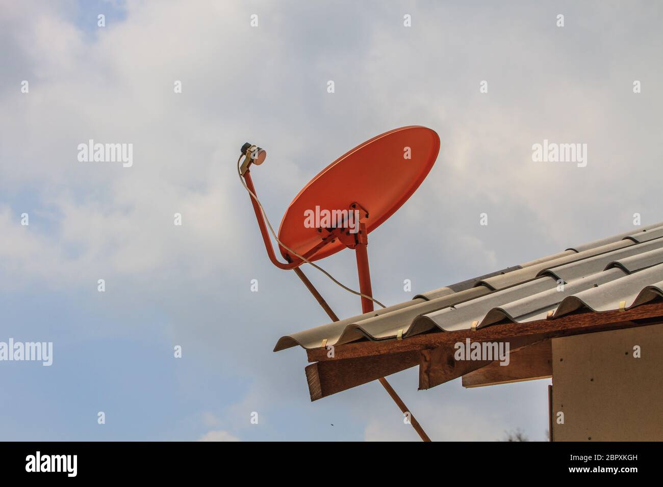 Red Satellite dish on the roof with sky background Stock Photo - Alamy