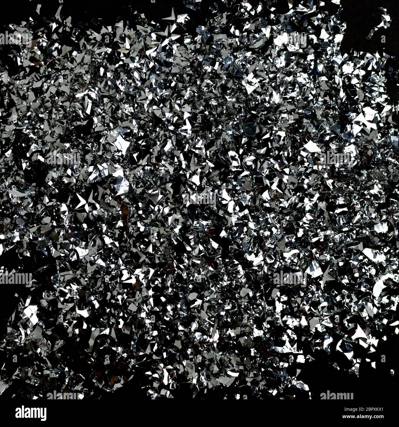 Silver confetti texture on a black background. Shiny backdrop. Stock Photo