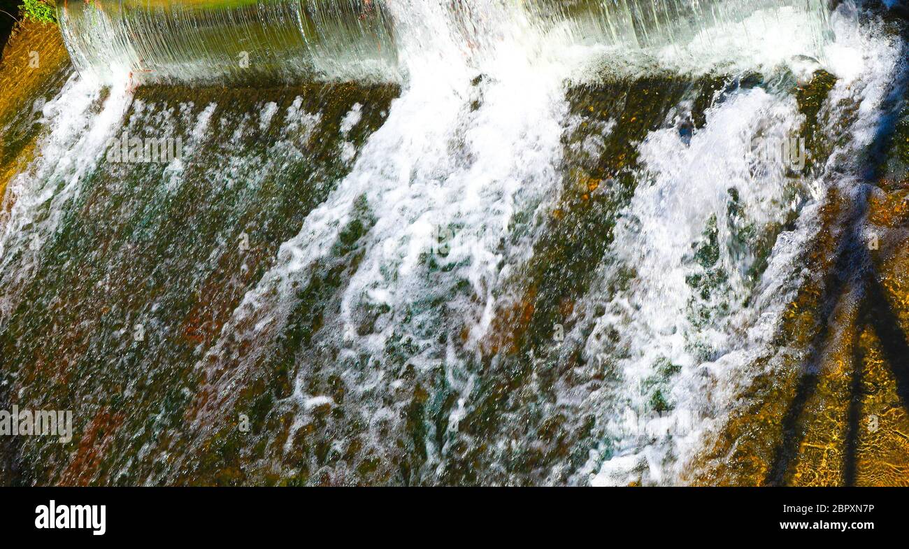 small waterfall on the urban river Stock Photo