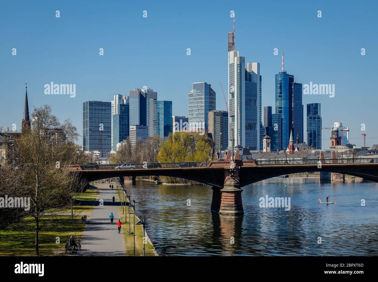 Frankfurt am Main, Hesse, Germany - Walkers on the banks of the Main during the Corona crisis with a ban on contact, in the back skyline of Frankfurt Stock Photo
