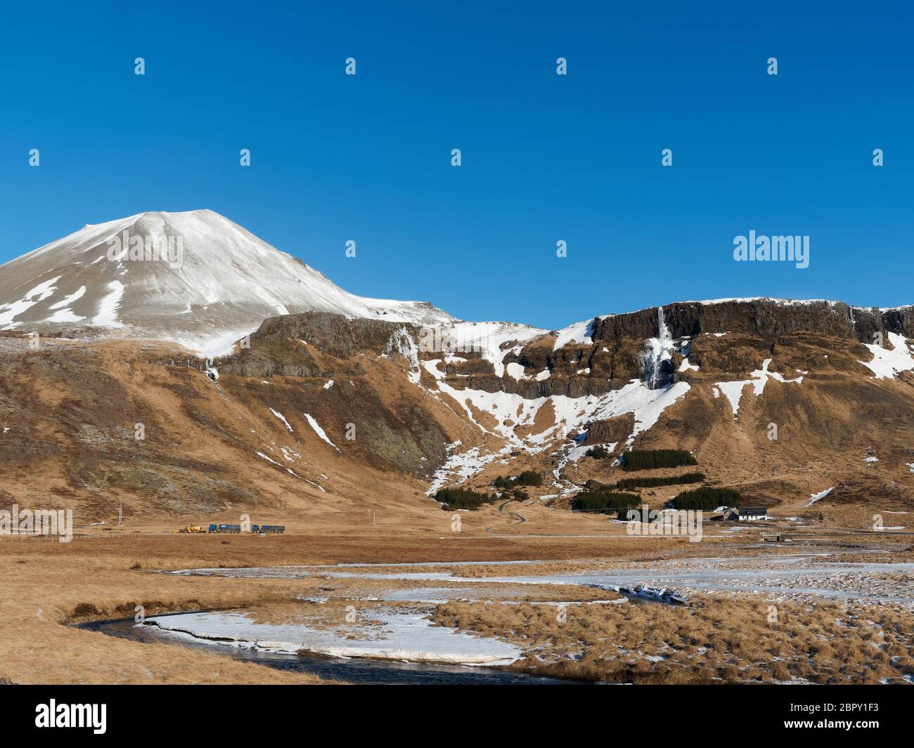 Hraunhofn with snow covered Maelifell mountain and Bjarnarfoss frozen waterfall in the background, West Iceland in winter Stock Photo