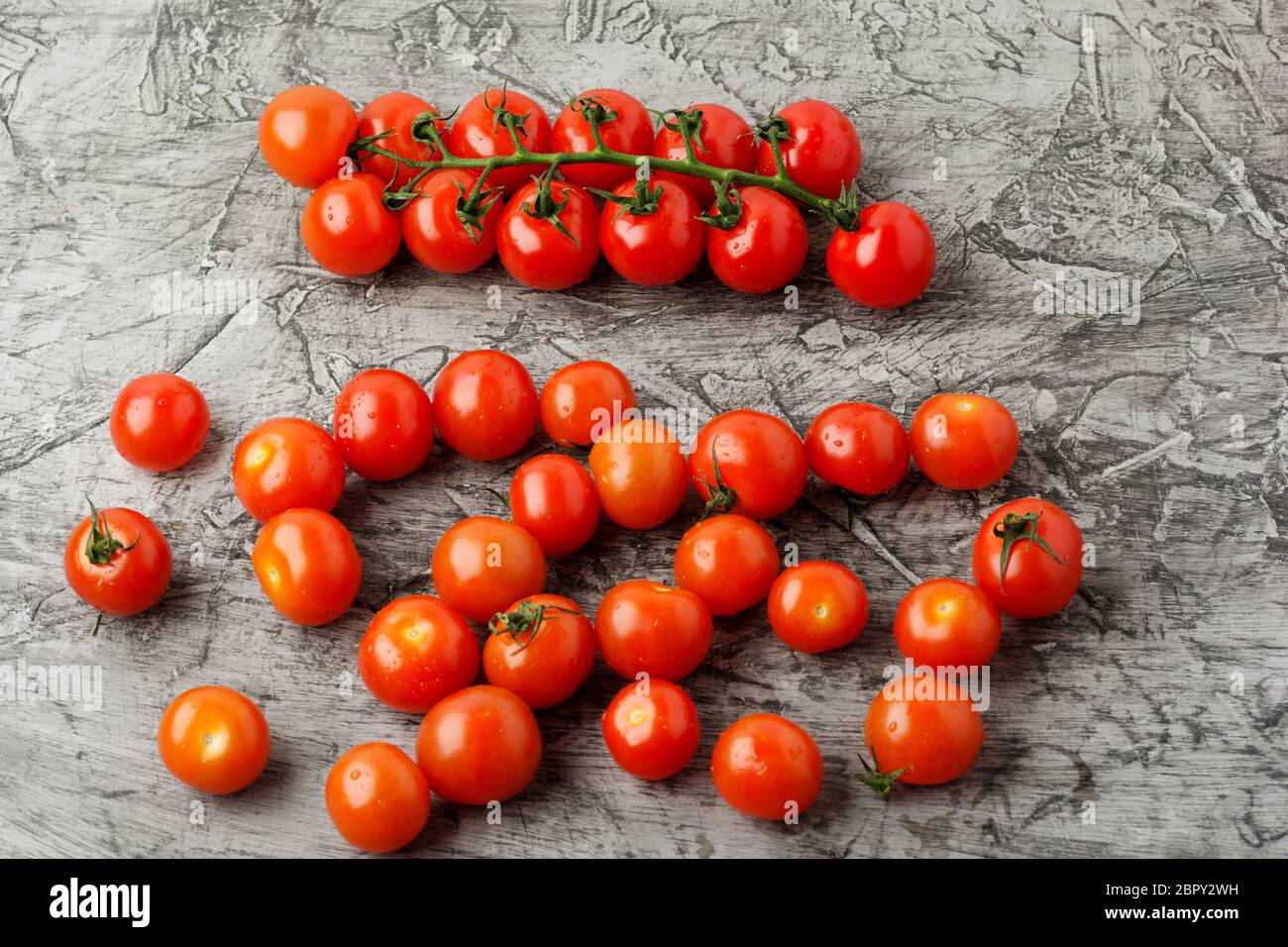 Tomato Cherry Ripe Group of cherry tomatoes on a gray concrete background. Ripe and juicy ...