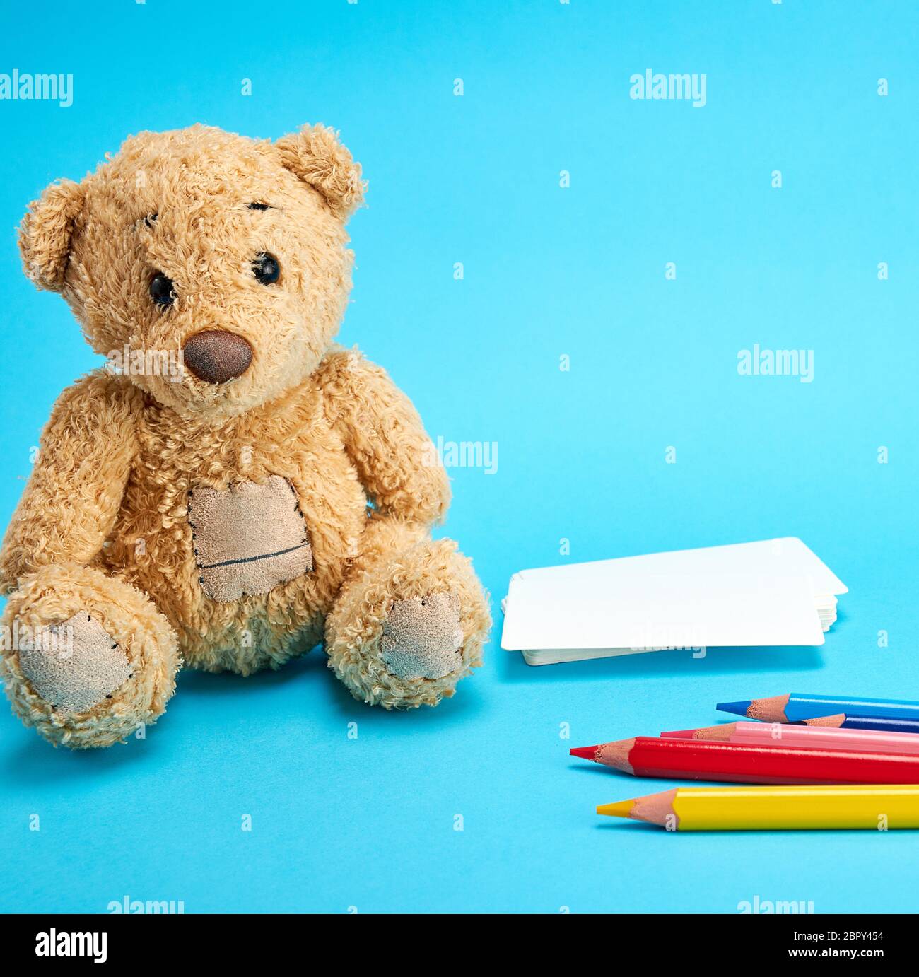 little brown teddy bear on a blue background Stock Photo - Alamy