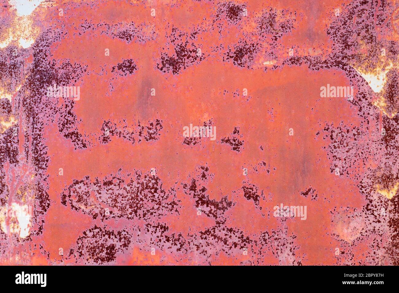 rusty iron wall with cracked red paint and stains Stock Photo
