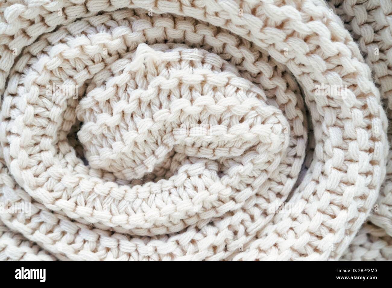 close-up of roll a white knitted plaid, soft selective focus. Stock Photo