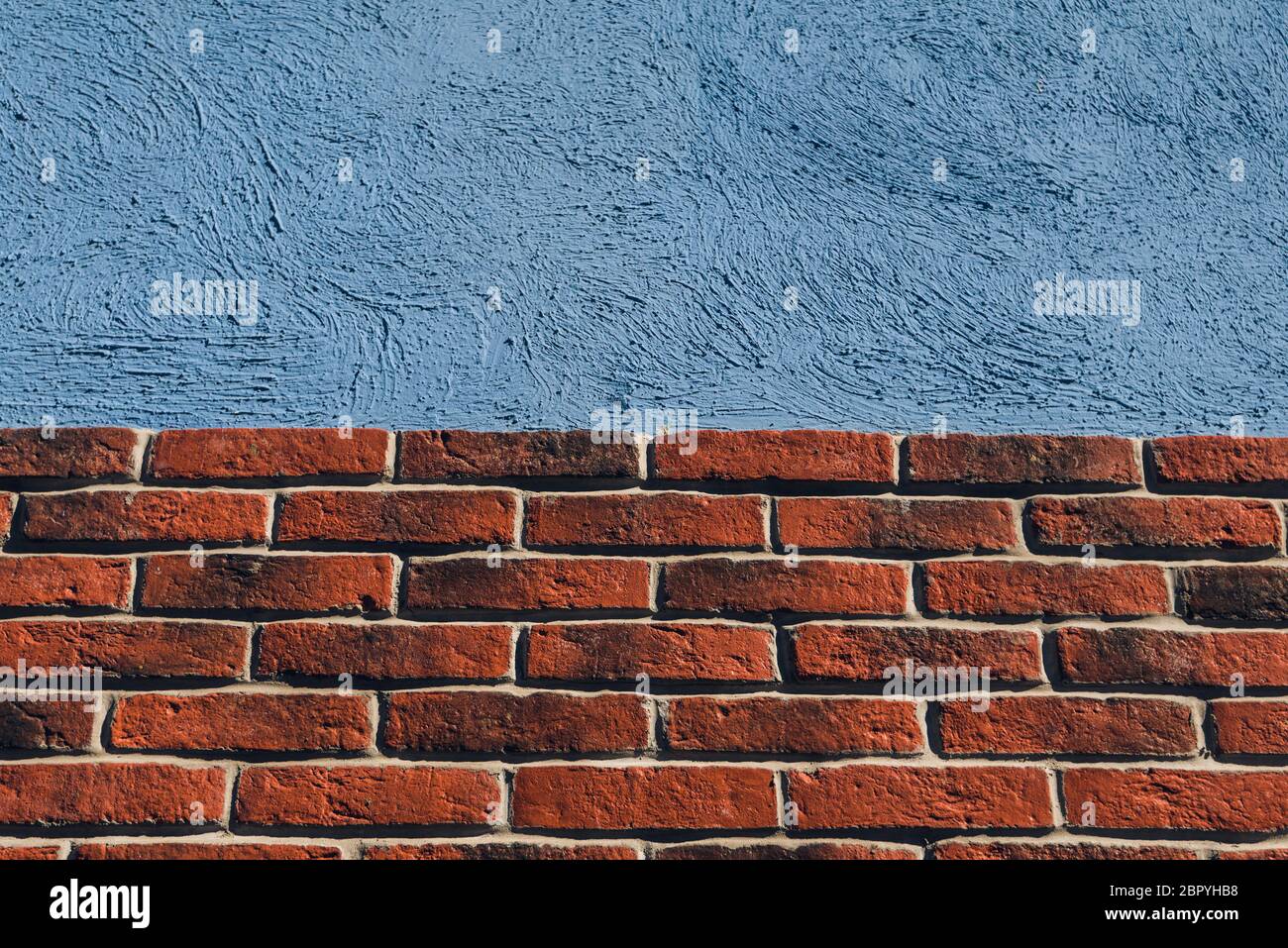 aged brick wall and blue concrete background for construction design Stock Photo