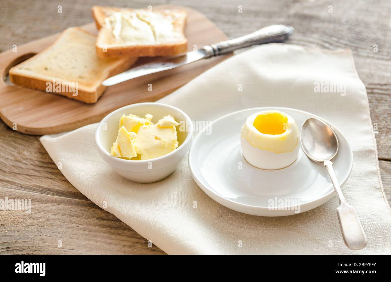 Boiled egg with crispy toasts on the wooden table Stock Photo