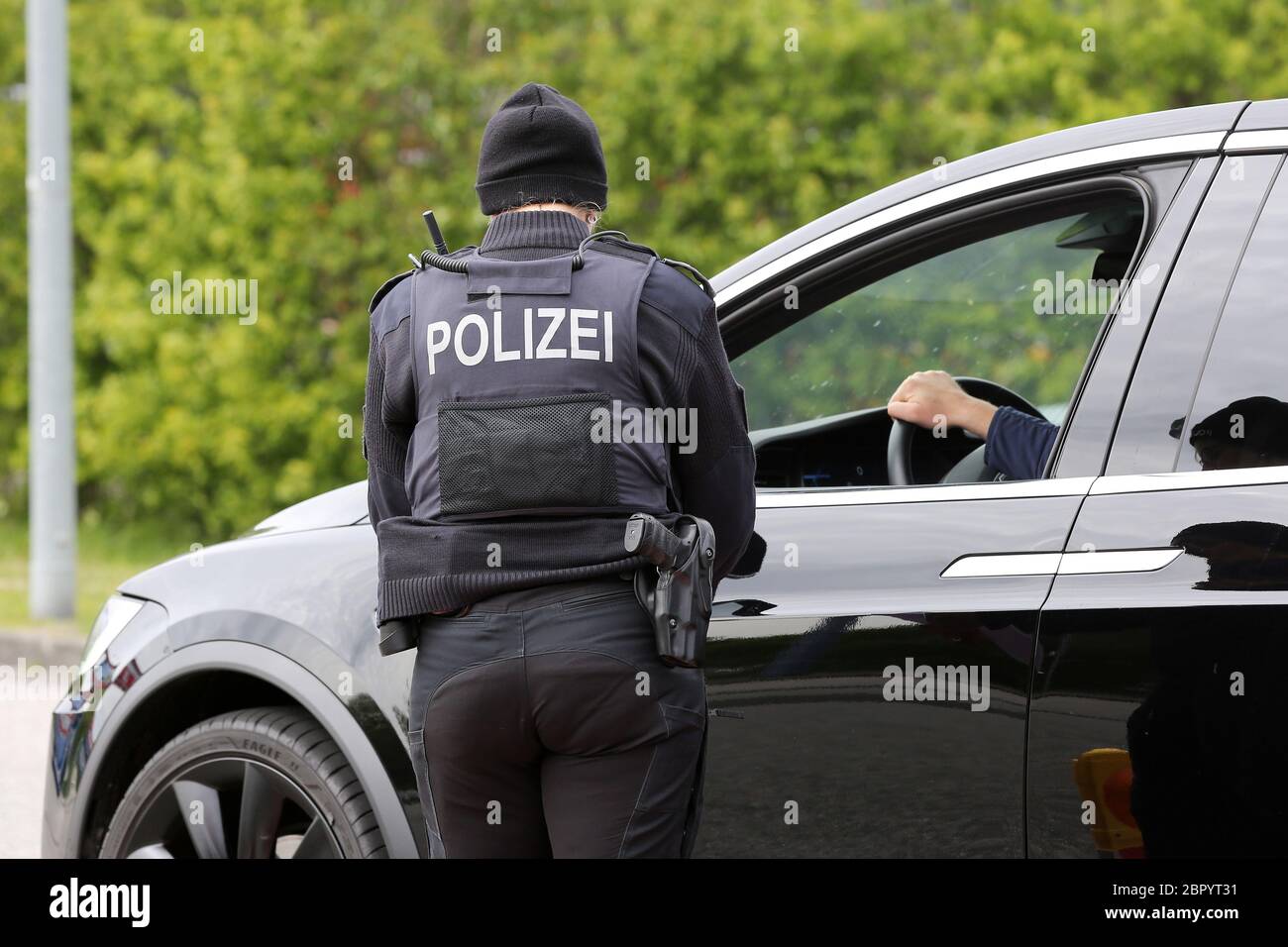 17 May 2020, Schleswig-Holstein, Niebüll: A policewoman checks a vehicle at the entrance to the Auto Train to Sylt. Photo: Bodo Marks/dpa/Bodo Marks Stock Photo
