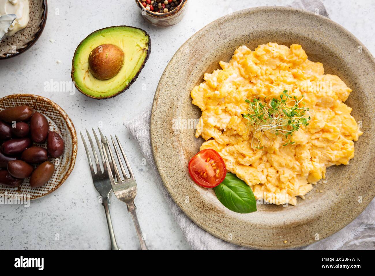 Fresh cooked scrambled eggs in a plate on white background, top view ...