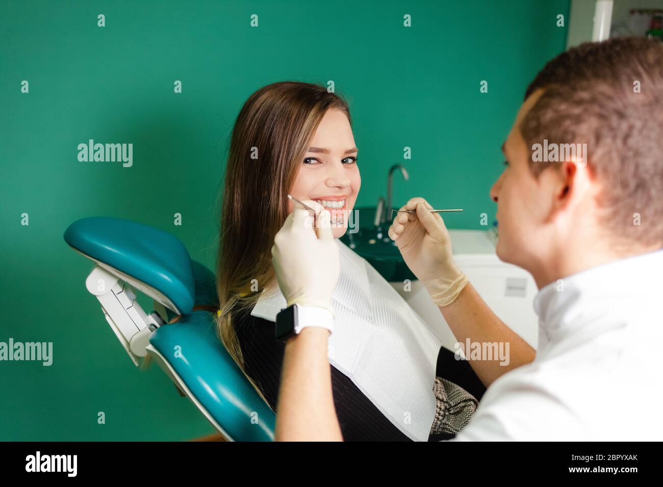 Dentist examines teeth of his patient. Attractive girl is being examined by a dentist Stock Photo