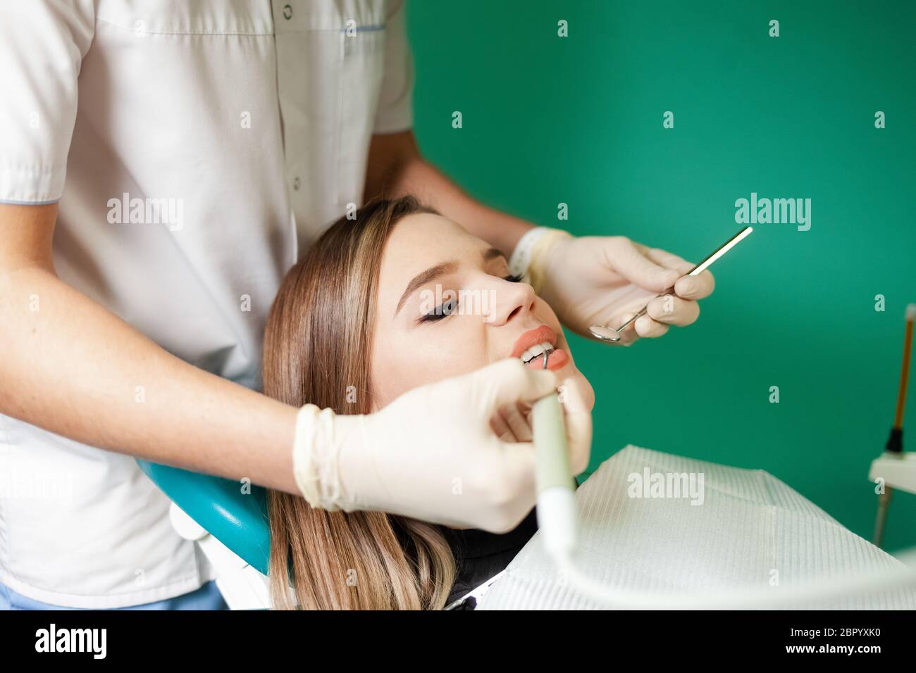 Dentist removes tartar from his patient’s teeth Stock Photo Alamy