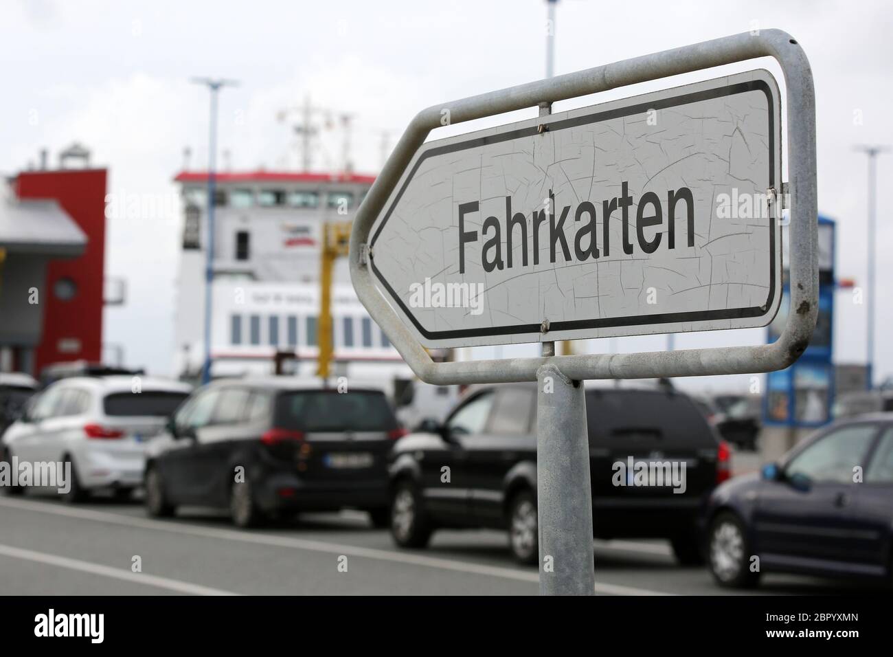 17 May 2020, Schleswig-Holstein, Dagebüll: A sign with the inscription 'Fahrkarten' (tickets) is in the harbour of Dagebüll, in the background vehicles are queuing in front of a ferry. In Schleswig-Holstein, loosening of the rules came into force on 18 May 2020 during the Corona crisis. Ferries brought tourists back to the islands of Föhr, Sylt or Amrum. Photo: Bodo Marks/dpa/Bodo Marks Stock Photo
