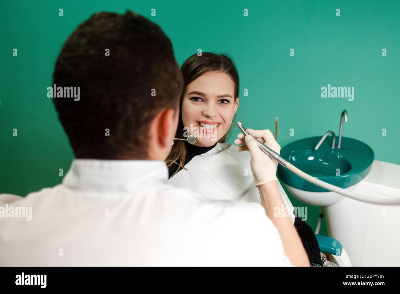 Dentist with a drill and a mirror is treating a patient teeth Stock ...