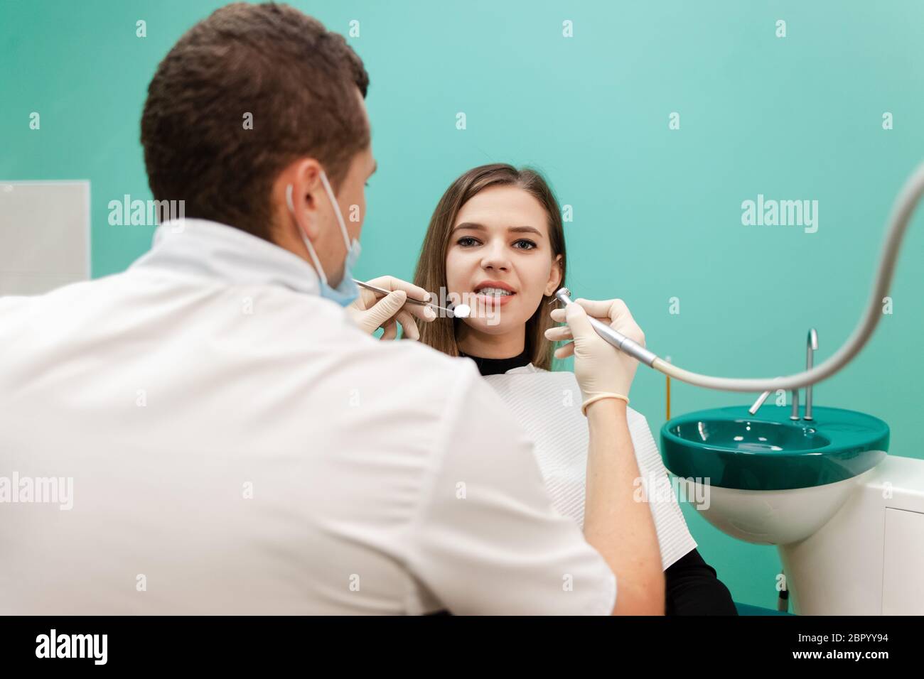 Dentist with a drill and a mirror is treating a patient teeth Stock ...