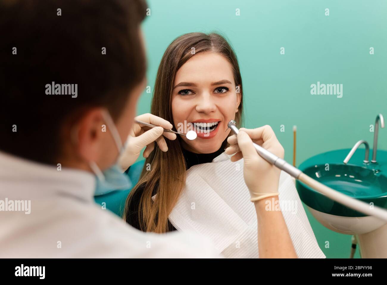 Dentist with a drill and a mirror is treating a patient teeth Stock ...