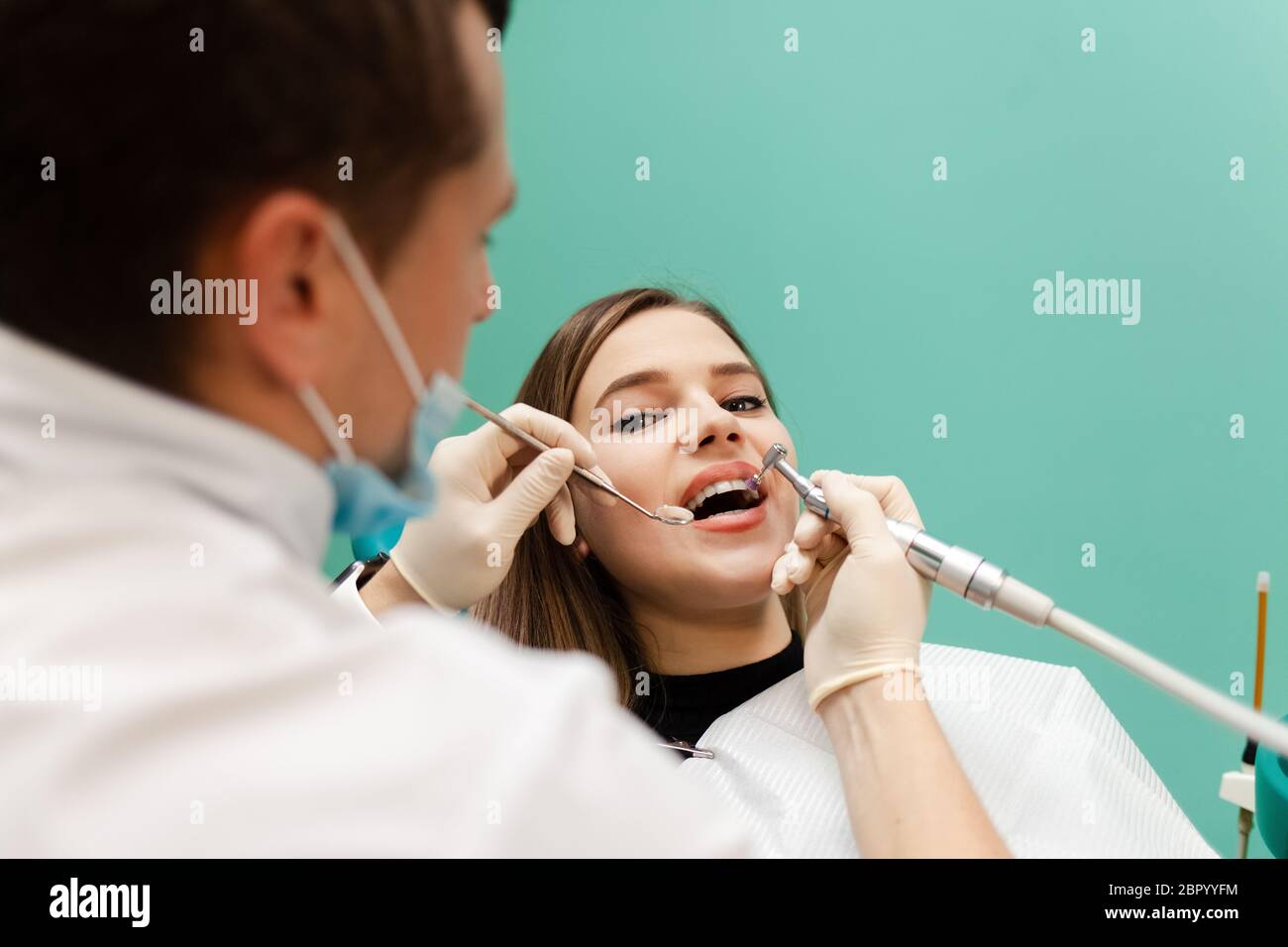 Dentist performs professional polishing of tooth enamel for woman