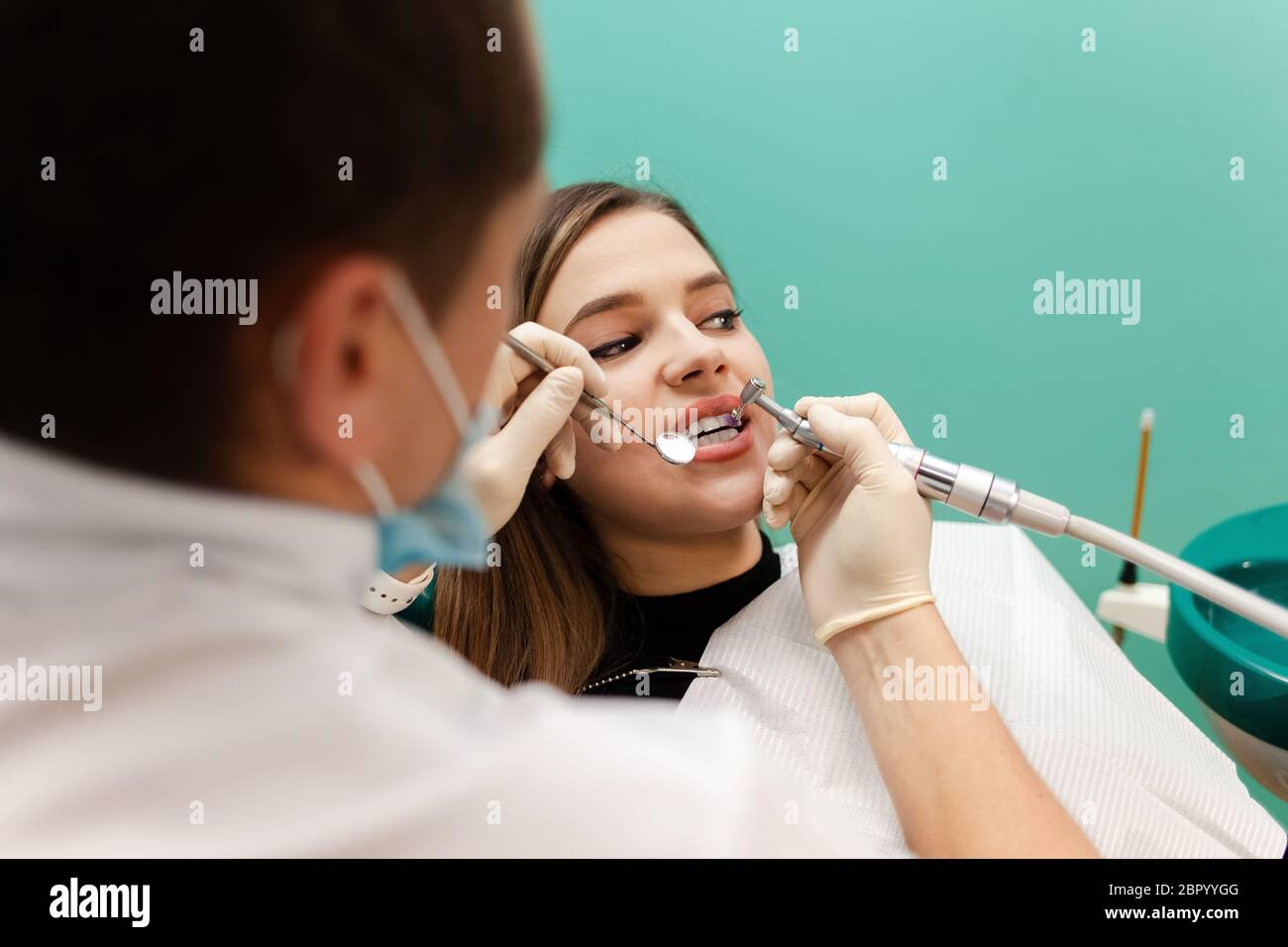 Dentist performs professional polishing of tooth enamel for woman