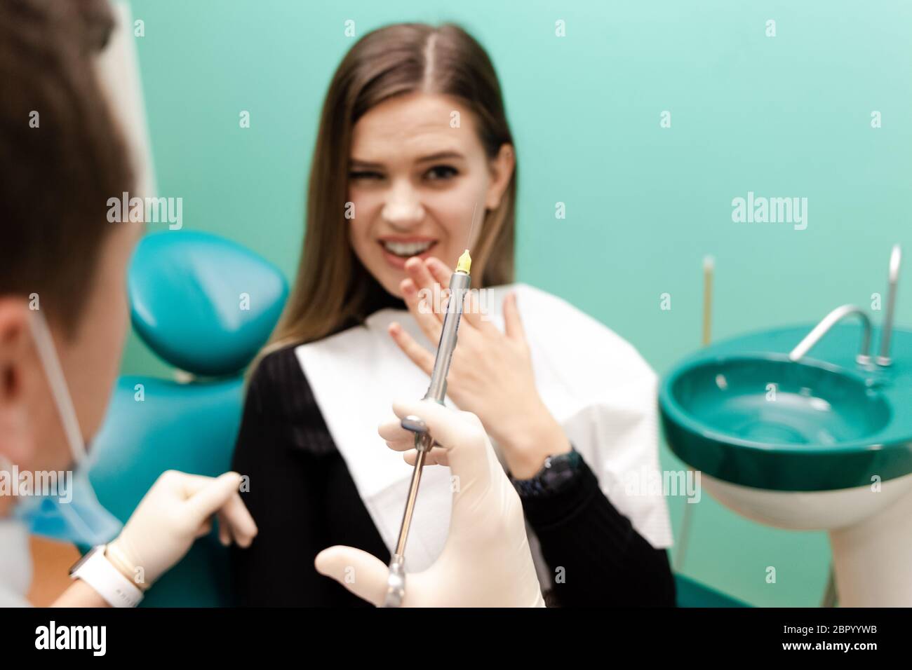 Dentist doctor holds an injection syringe. Girl has to make an ...