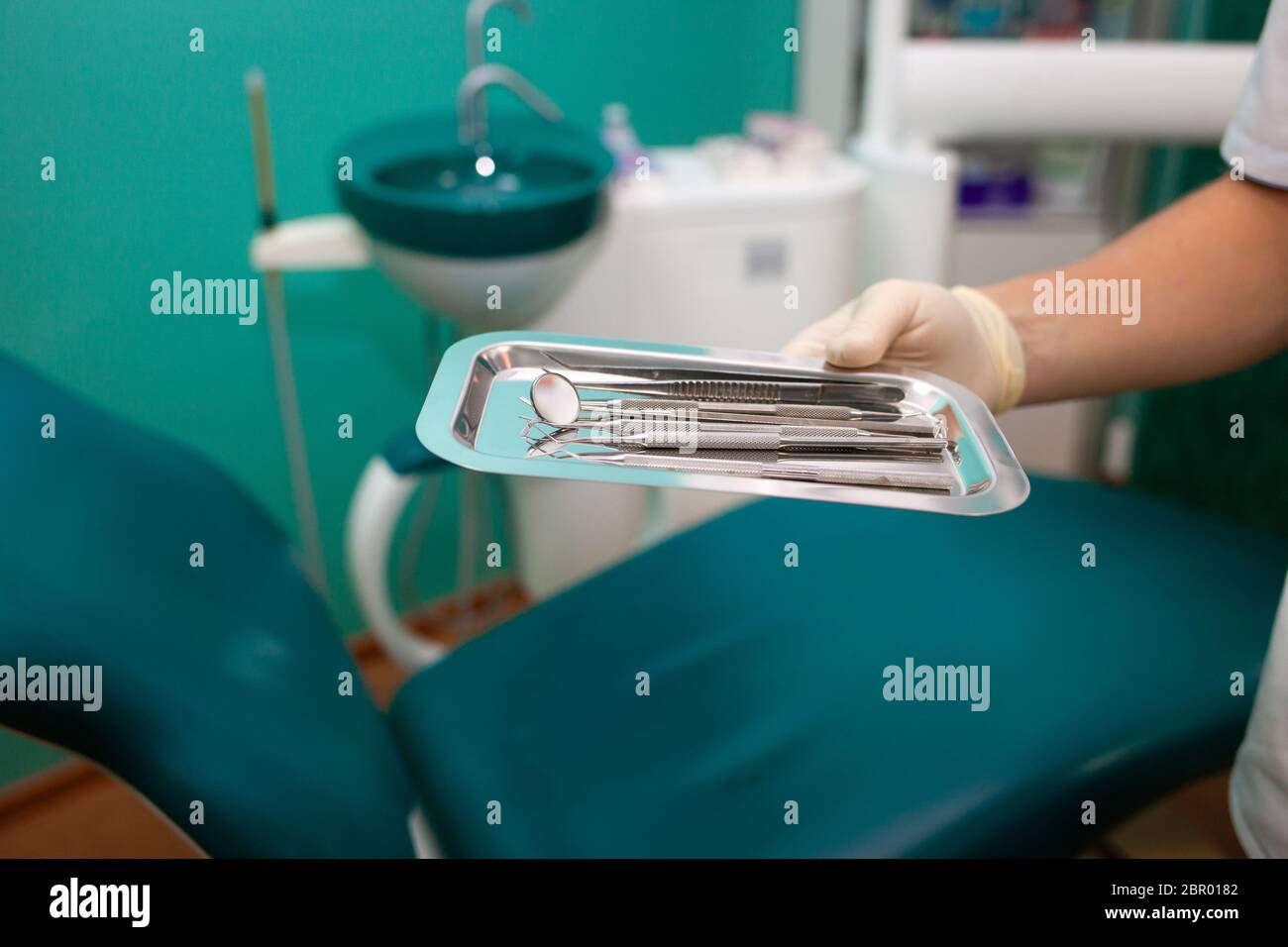 Dentist doctor holds many dental instruments in his hands. Sterile