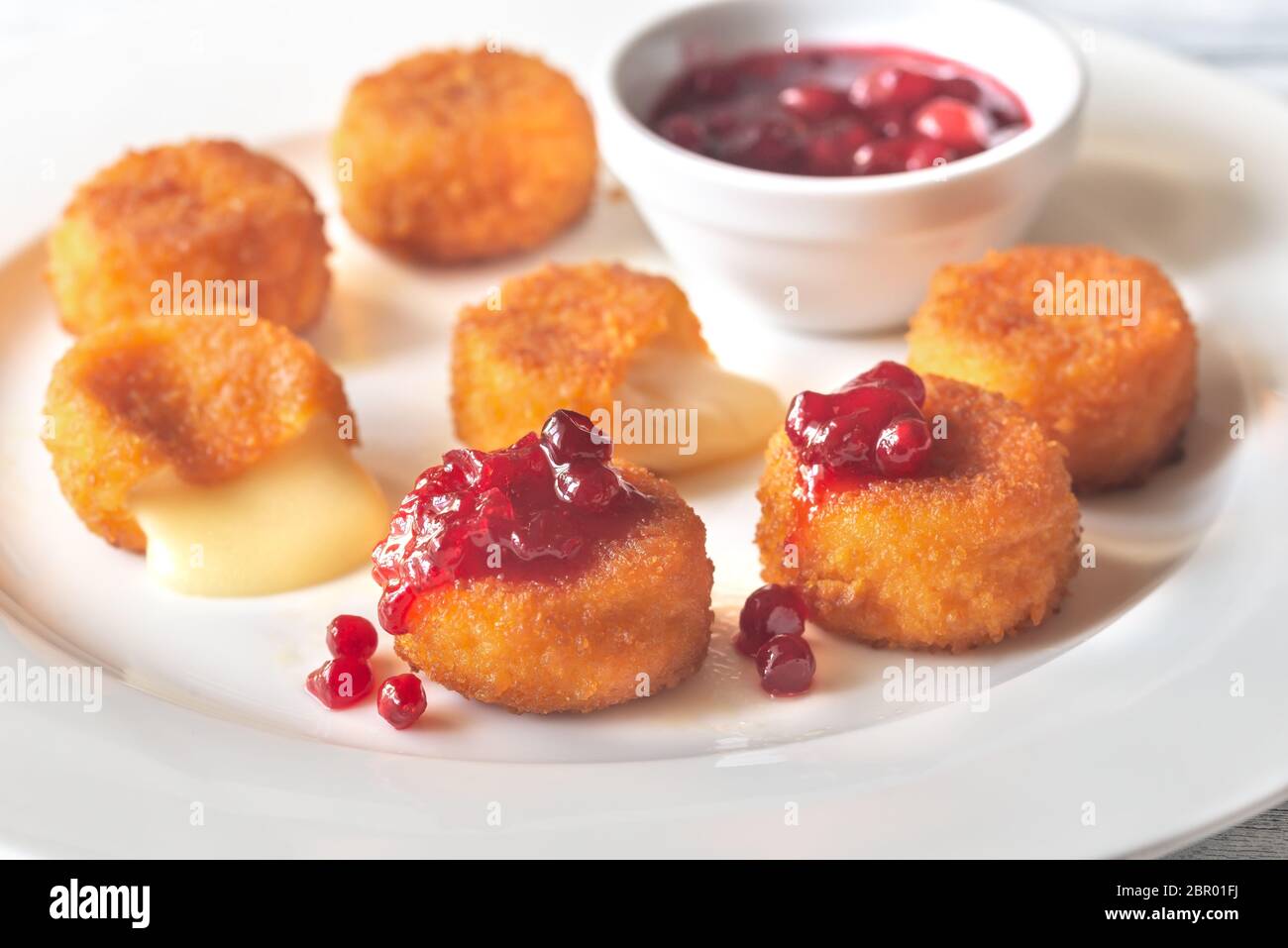 Camembert nuggets with cranberry sauce on the white plate Stock Photo