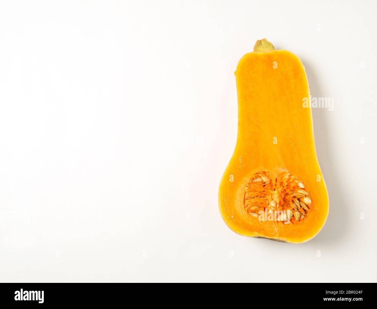 Half a butternut squash with seeds isolated on a white background with copy space Stock Photo