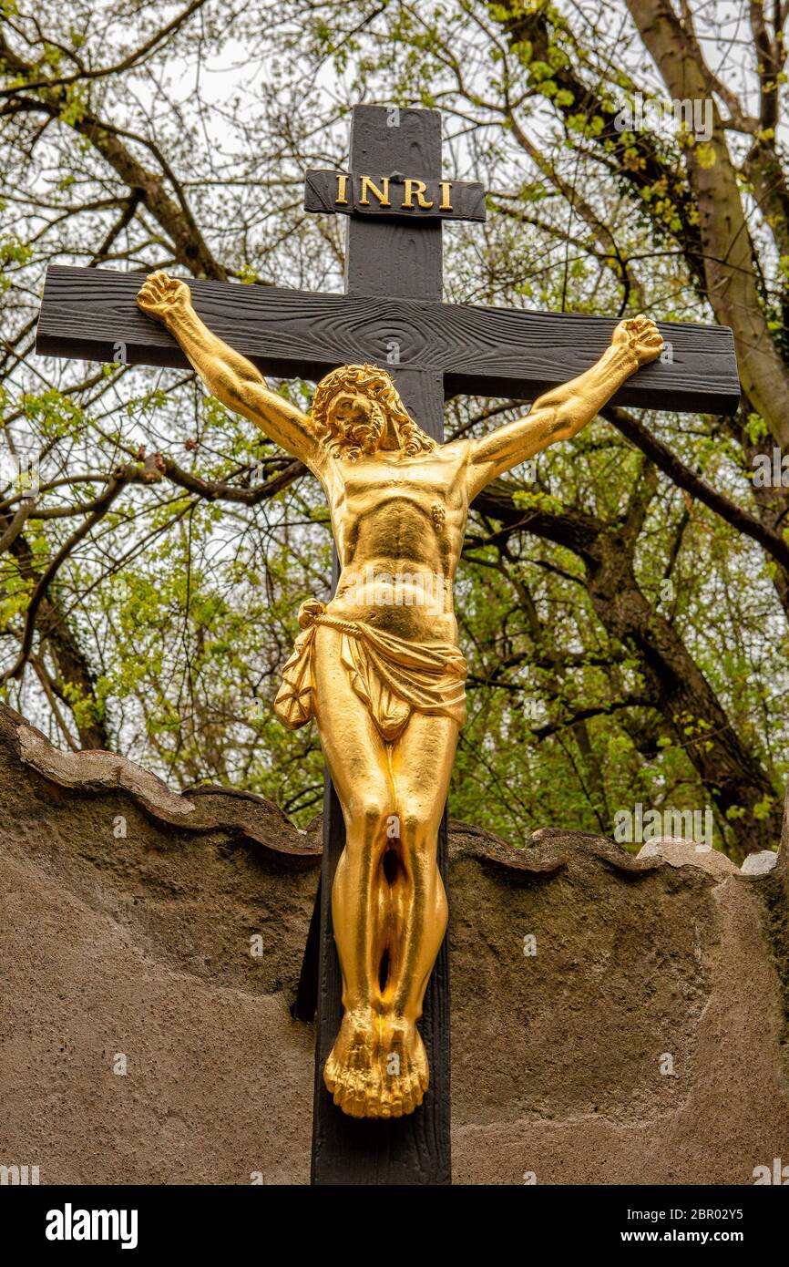 Golden crucifix of Christ on a wooden cross near the walls of