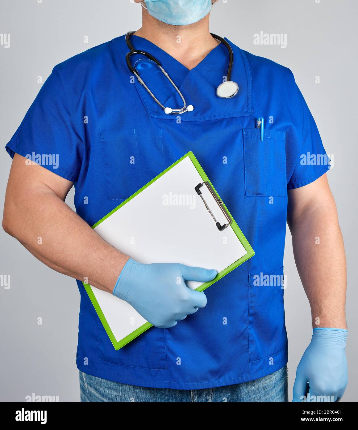 doctor in blue uniform and sterile latex gloves holds clipboard with a ...